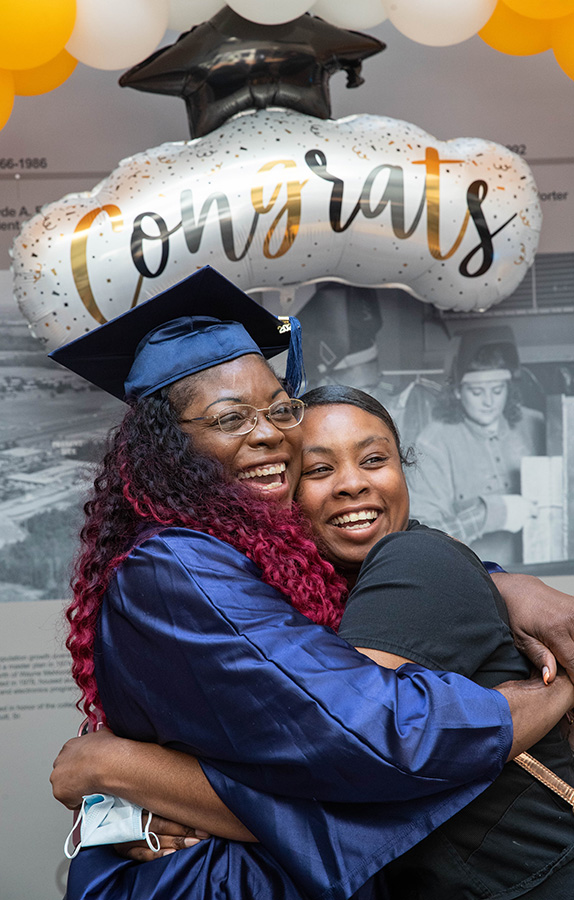 Graduate hugging loved one.